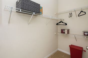 a spacious closet with shelves and hooks and a basket in the corner of the room